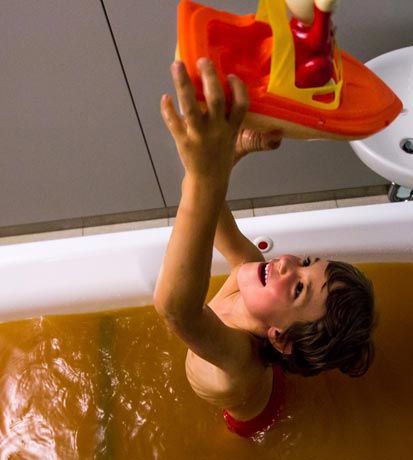 Un bambino gioca felice in una vasca con olio presso le Terme di Levico e Vetriolo
