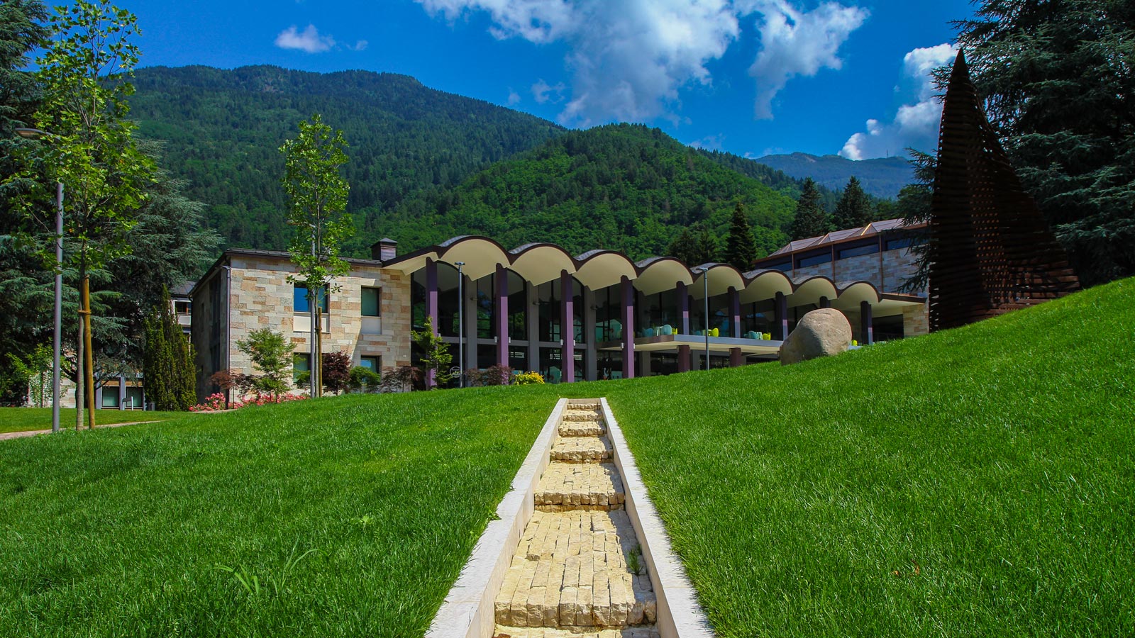 La facciata delle terme di Levico con un prato verde